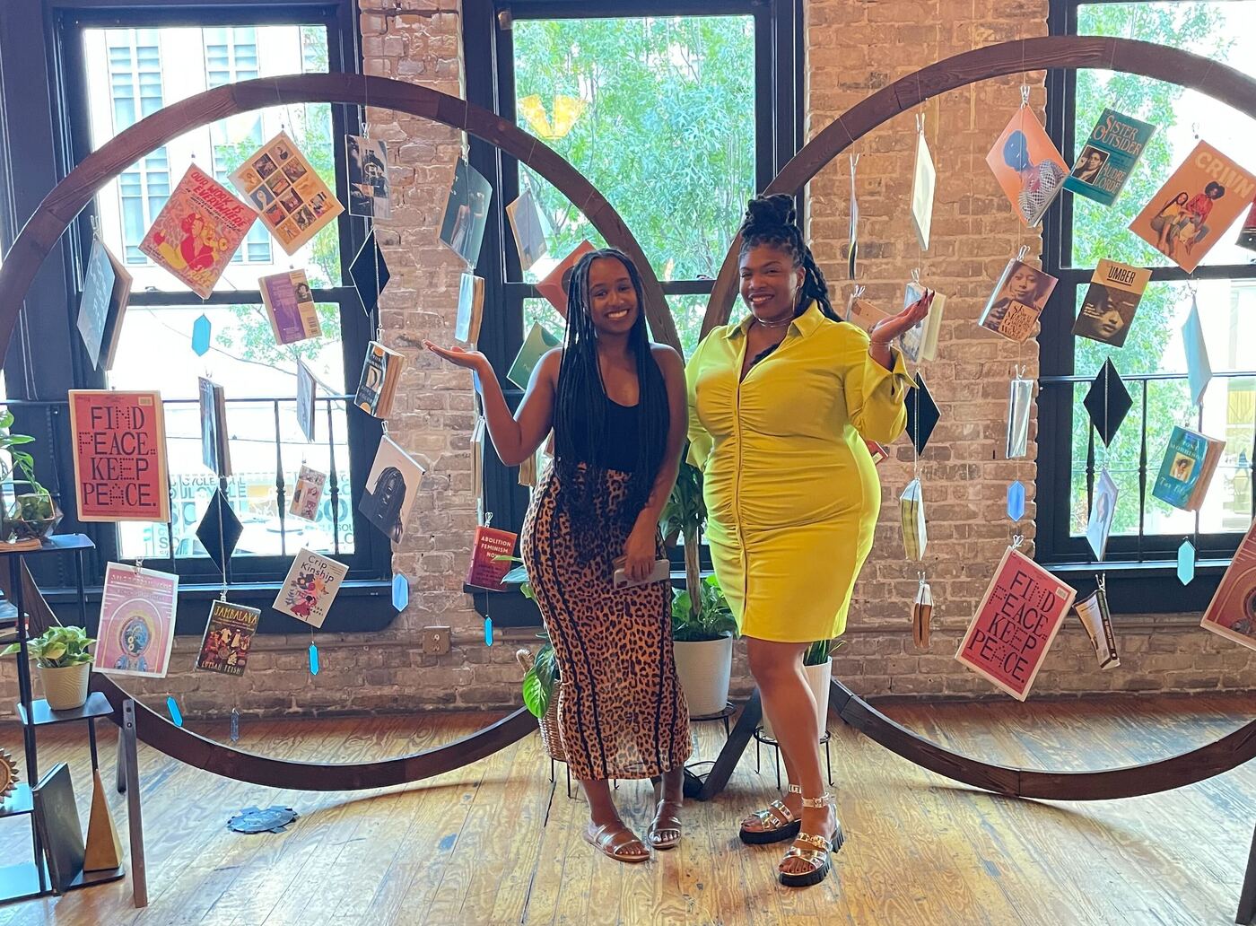 Diamond Hardiman and Venneikia Williams in front of the Black Future Newsstand exhibit at AfroTech