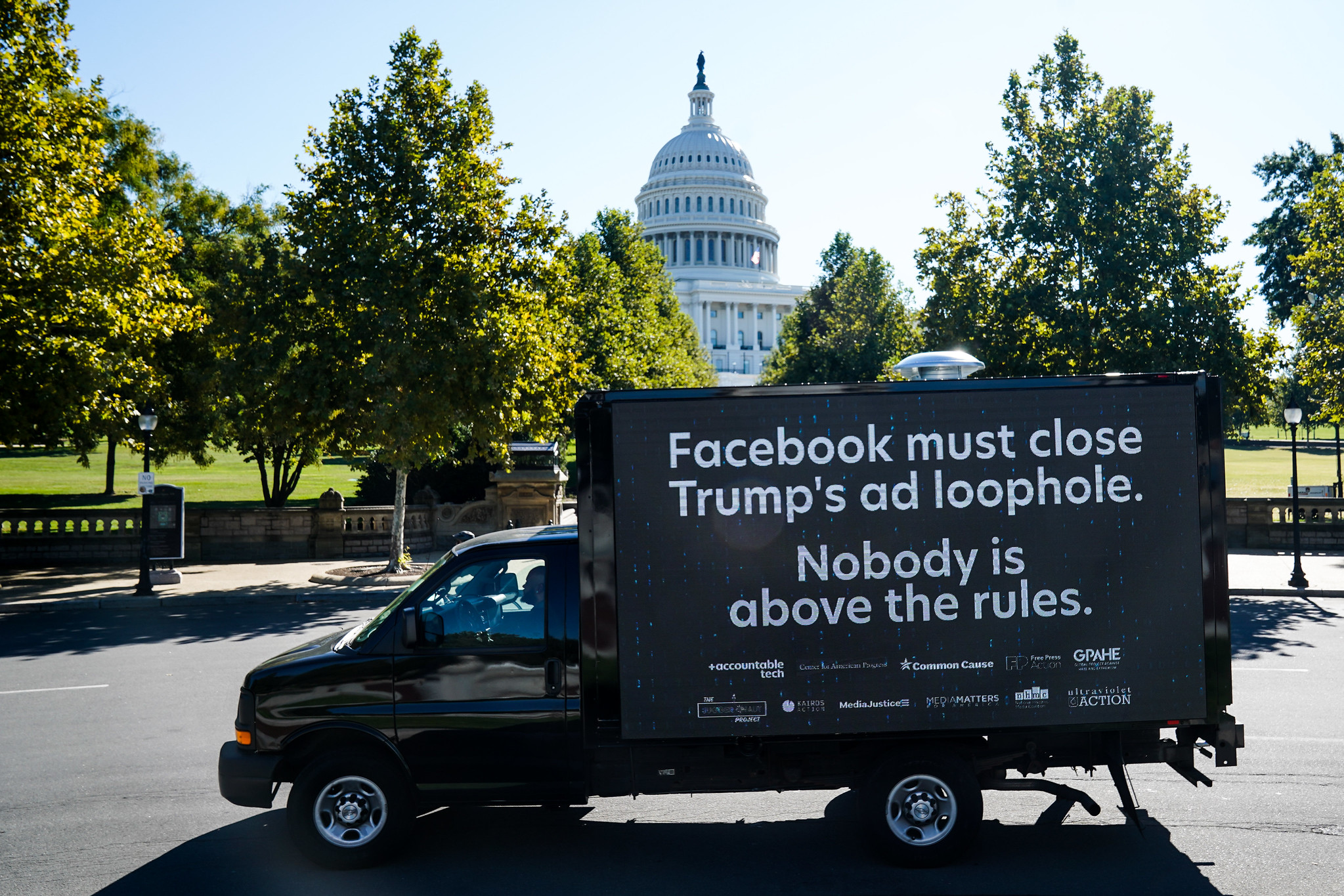 Mobile billboard reading "Facebook must close Trump's ad loophole. Nobody is above the rules."