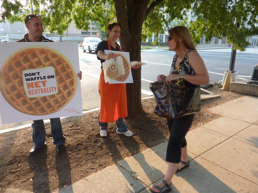 Free Press staffers bearing waffles and "Don't waffle on Net Neutrality" signs outside FCC headquarters
