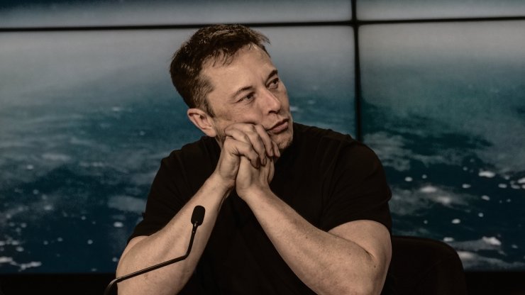 Elon Musk sitting at a table