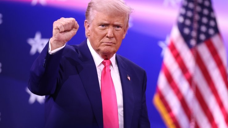Trump holding a fist up at the 2025 Conservative Political Action Conference