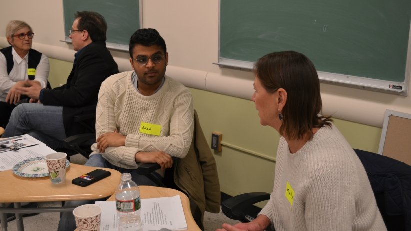 Man and woman talking at table during 37 Voices workshop