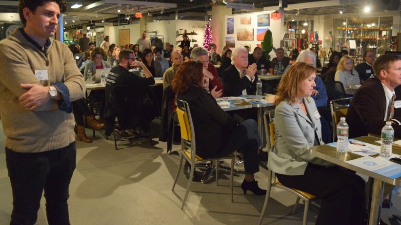 Mike Rispoli standing by people sitting at tables