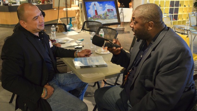 Reporter interviewing man at table