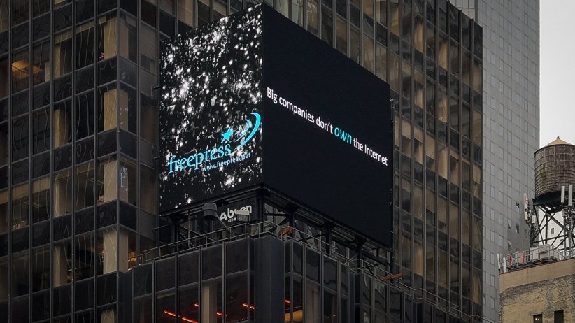 Video billboard reading "Big companies don't own the internet"