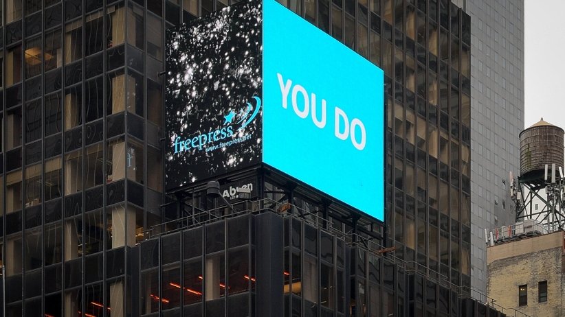 Video billboard reading "YOU DO"