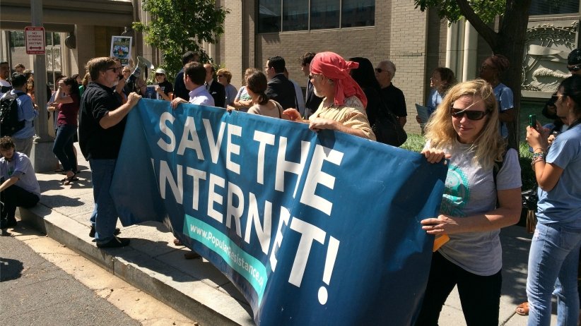 Activists holding banner reading "save the internet"
