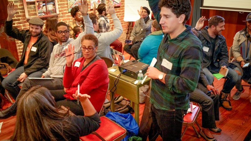 People raising hands in response to a question