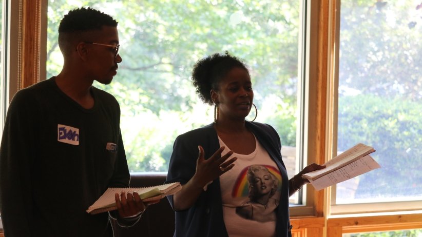 A man and woman speaking in front of the group
