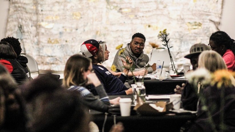 People talking at multiple tables during Charlotte event