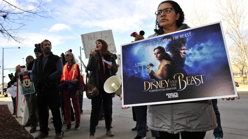 Activist holding reworked Beauty & the Beast sign
