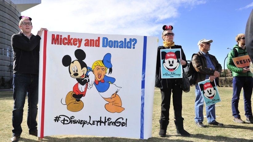 Activists holding Mickey & Donald banner