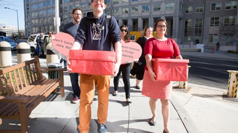 People carrying boxes of petitions to the FCC