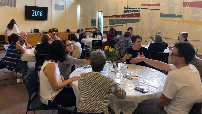 People sitting at various circular tables