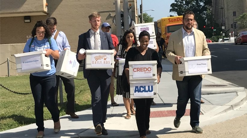 Activists carrying boxes of petitions to the FCC