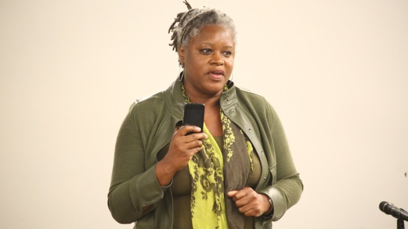 Woman holding up phone and speaking