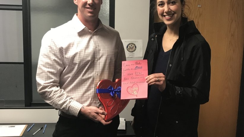 Two Net Neutrality activists holding a valentine and candy in front of Rep. Aguilar's office.