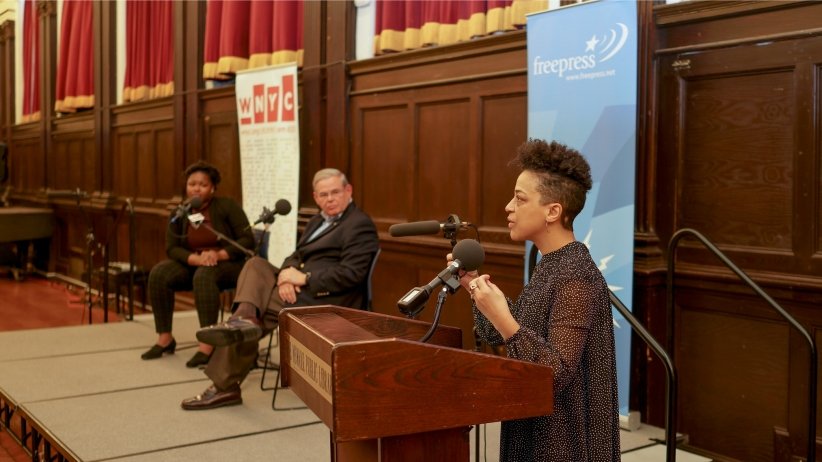 Woman at podium speaking into microphone