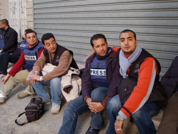 Journalists in Gaza sitting on the ground