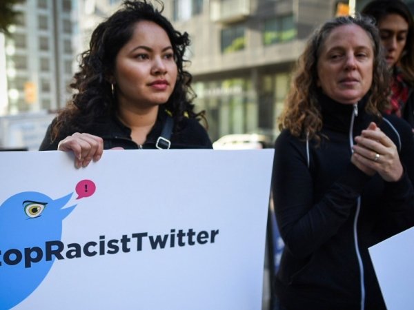 Protesters outside Twitter headquarters holding signs reading "Stop Racist Twitter"