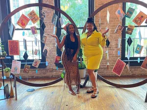 Diamond Hardiman and Venneikia Williams in front of the Black Future Newsstand exhibit, which explores Black liberation, at Afrotech