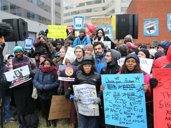 Dozens of Net Neutrality activists holding signs
