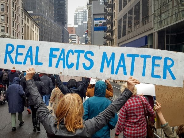 Protesters holding a banner reading "Real Facts Matter"