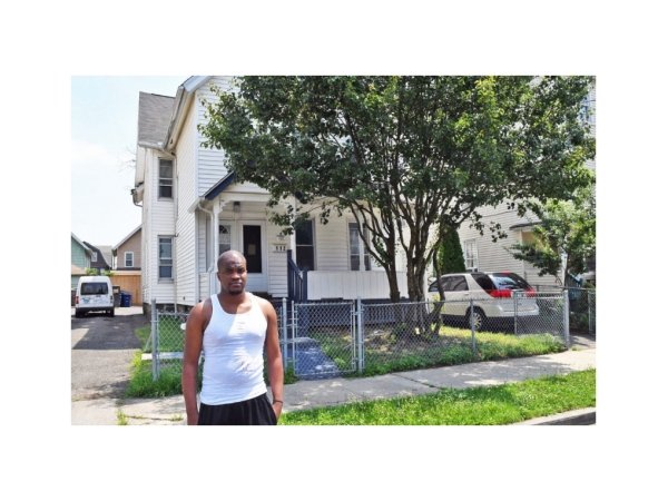 Aaron Tucker standing in front of a house