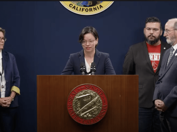Free Press Action's Qing Saville at podium delivering remarks about a California local journalism bill 