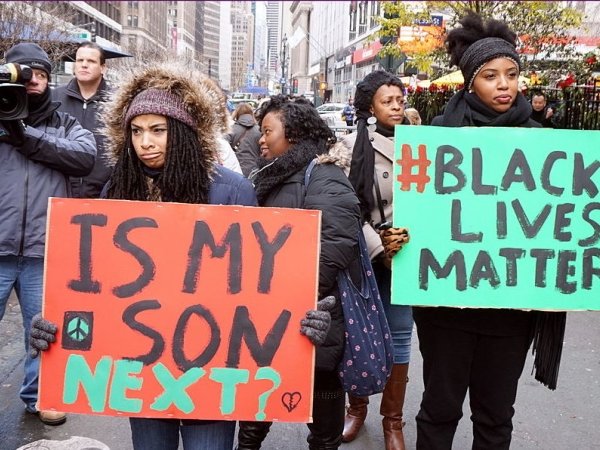 Women holding posters at a Black Lives Matter protest
