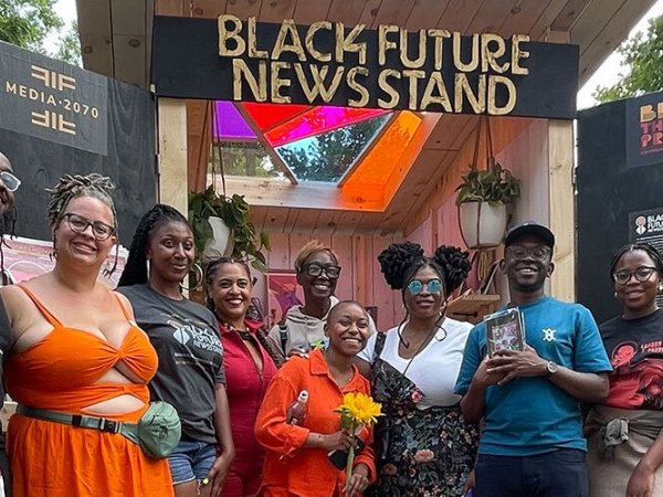 Organizers and supporters standing in front of the Black Future Newsstand installation