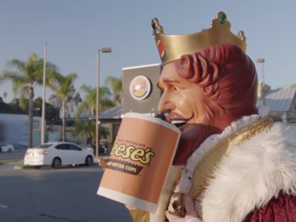 Burger King character drinking from oversized Reese's mug