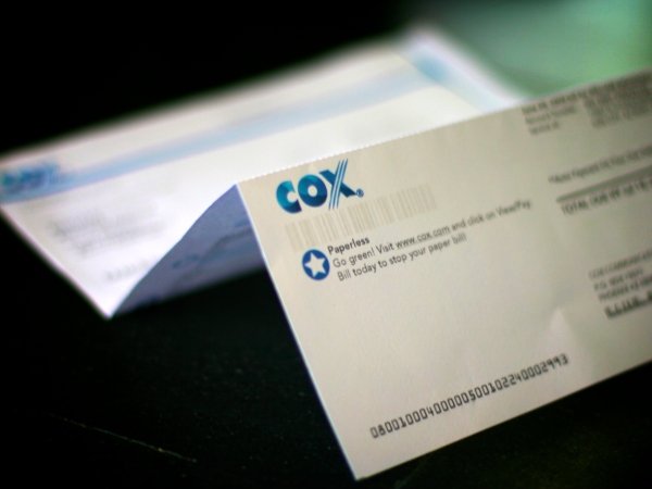 A Cox cable bill open on a table