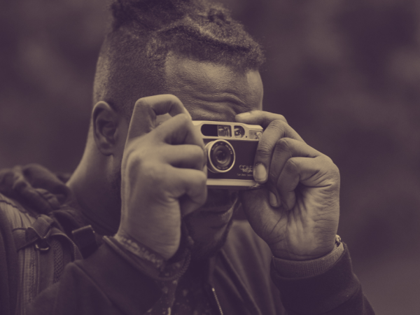Sepia-toned photo of man holding a camera to his face
