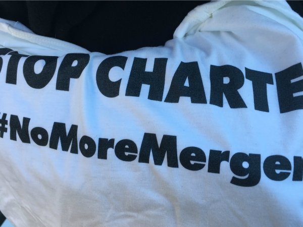 T-shirt reading "Stop Charter / #NoMoreMergers