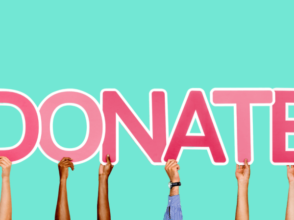 Hands holding up the word "Donate"