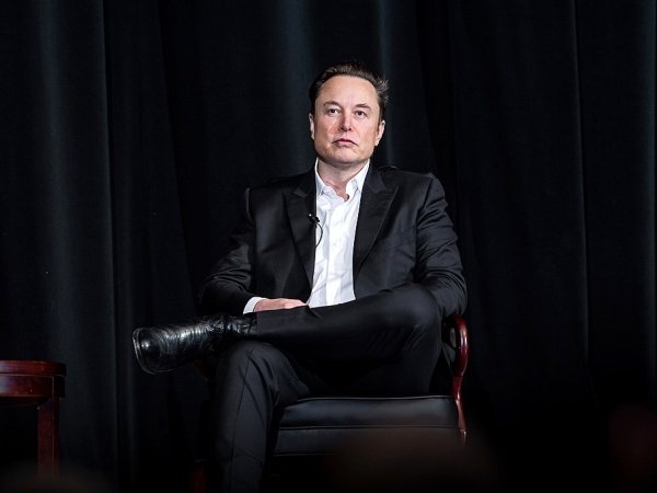 Elon Musk sitting in a chair on a stage at the U.S. Air Force Academy in Colorado