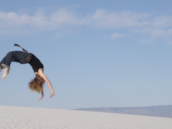 Woman doing back handspring on a beach
