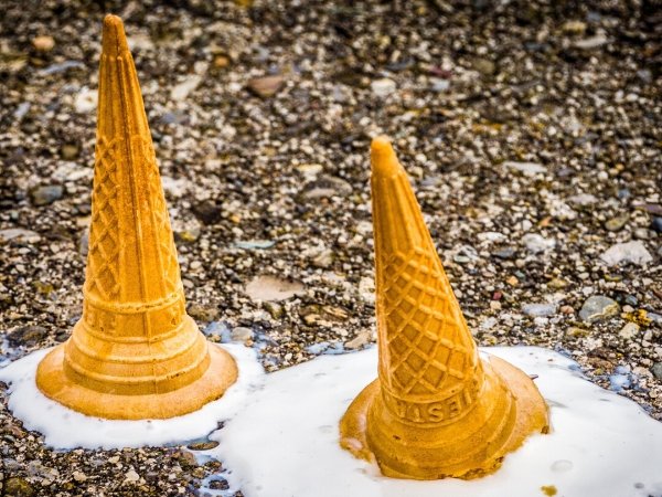 Two upside-down ice-cream cones melting on the ground