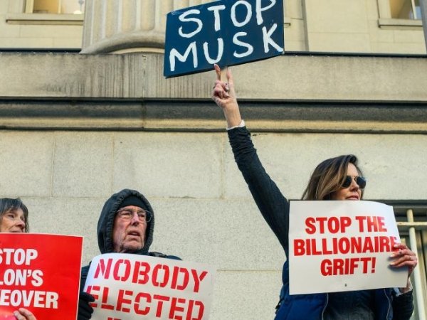 Protesters holding signs reading "Nobody elected Musk" and "Stop the billionaire grift"