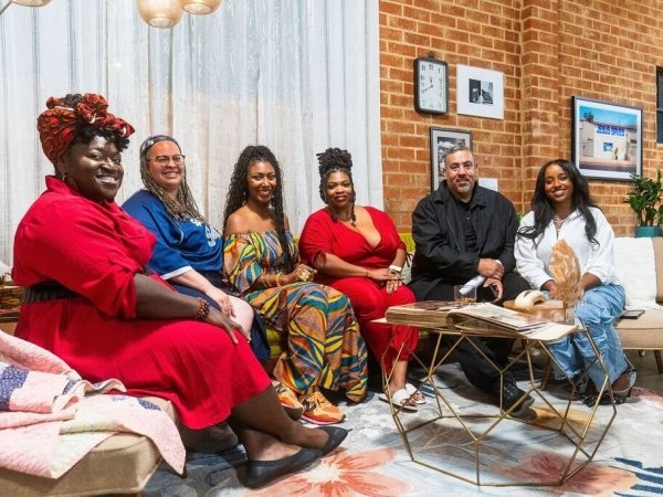 Members of the Media 2070 team sit on a couch at the Black Future Newsstand exhibit in Los Angeles