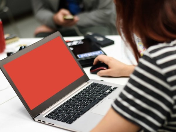 Woman using laptop with red screen