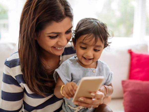 Mother and child look down at cell phone