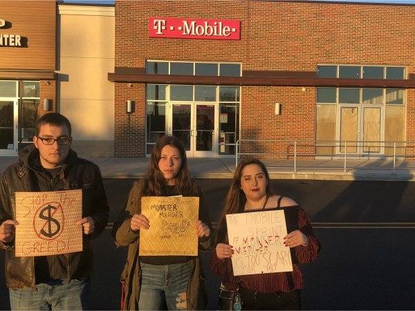 Three activists protesting the T-Mobile/Sprint merger