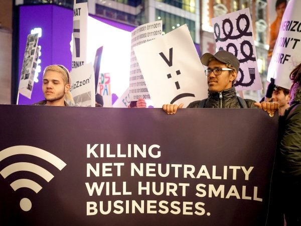 Activists holding sign reading "Killing Net Neutrality will hurt small businesses"