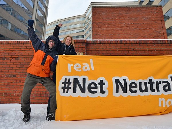Net Neutrality activists holding sign reading "Real Net Neutrality now"