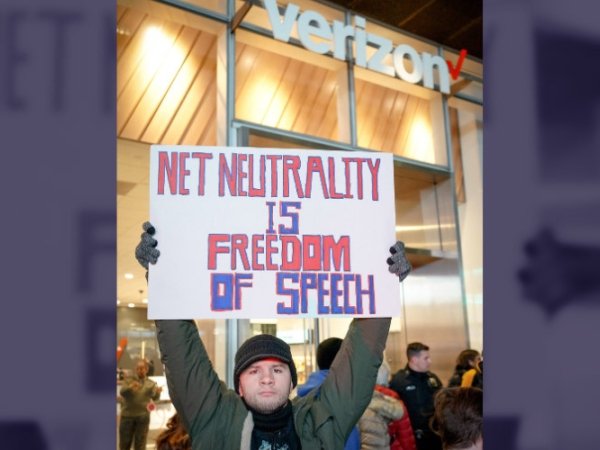 Net Neutrality activist in NYC holding a poster reading "Net Neutrality is freedom of speech"