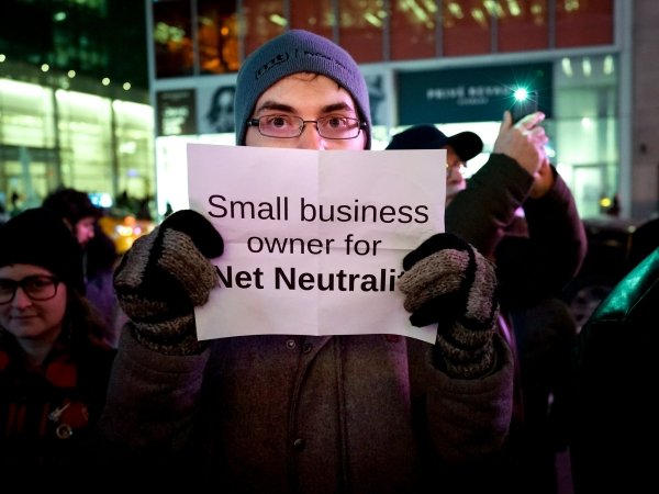 Activist holding sign reading "Small business owner for Net Neutrality"