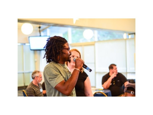 Man speaking into microphone next to woman