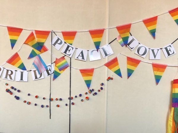 Rainbow flags with the signs "Pride," "Peace" and "Love"